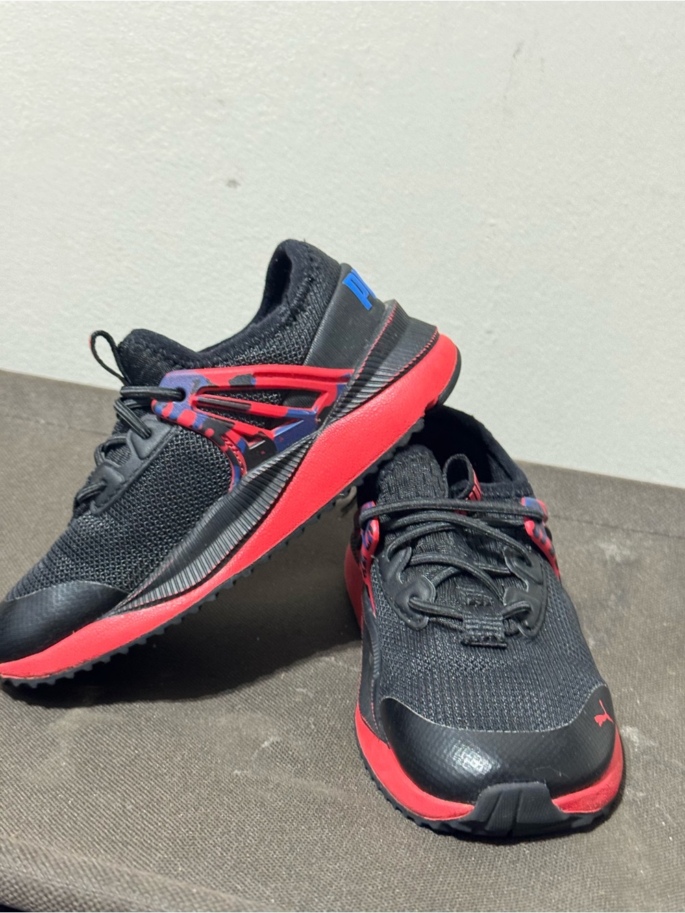 Puma Kids Black Sneakers with Red Soles and Blue Accents